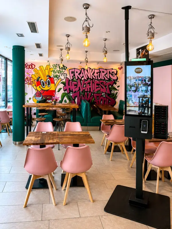 Dominion Food Revolution – Gastraum mit Bestell-Kiosk und Graffiti-Wandbild